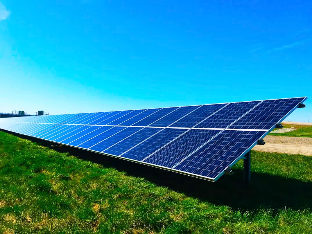 Wide landscape of solar panels on hills under bright sunlight